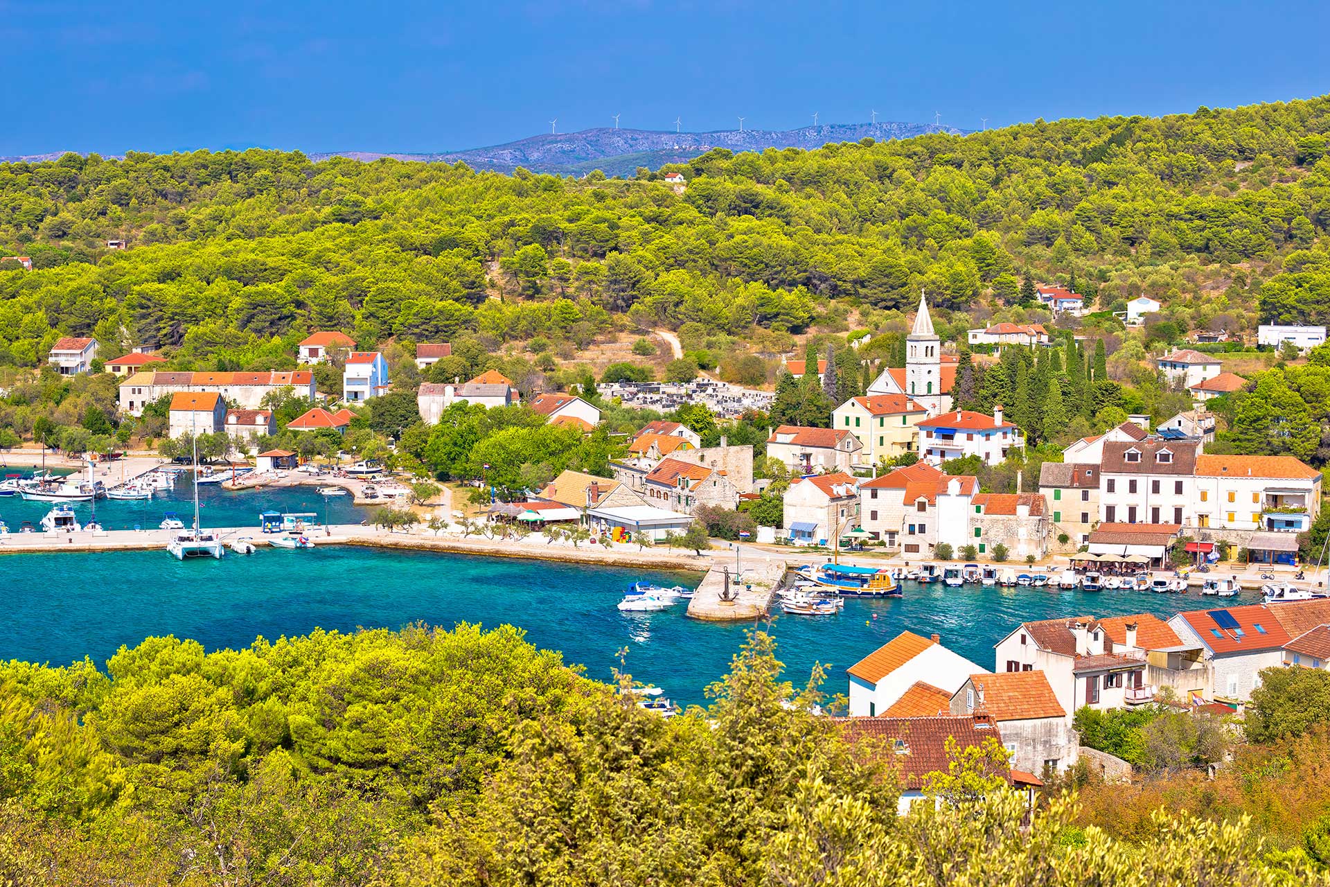 Zlarin island with old Port and boats moored on the pear