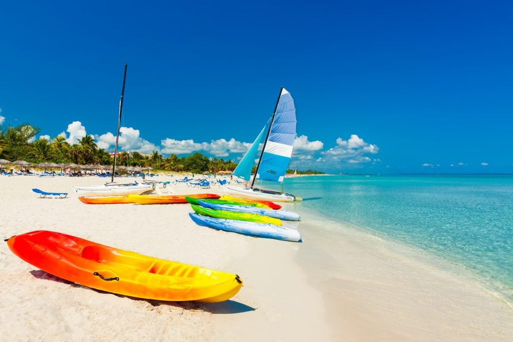 Colorful kayaks and sport catamaran on a beach in Cuba