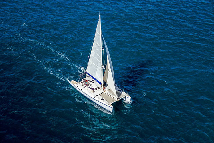 catamaran sailing with all sail up aerial view