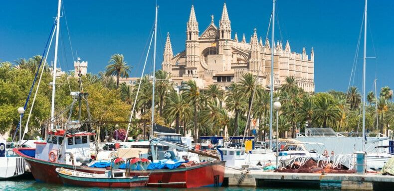 Boats on the dock near Spanish building | Sebastus Sailing