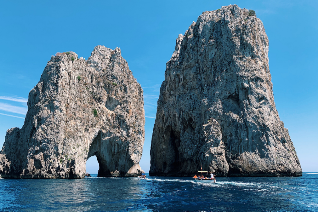 ein Blick auf die Faraglioni-Inseln an der Amalfiküste und die Besichtigung von Touristenbooten