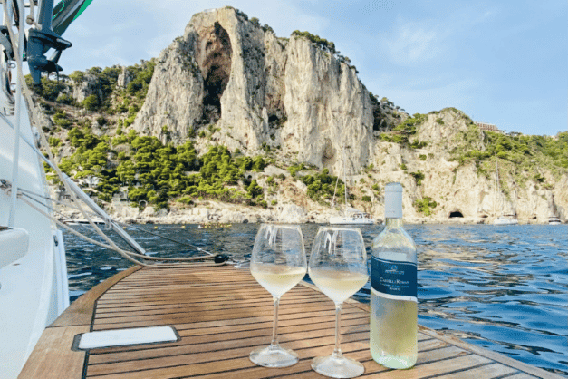 Flasche Wein und zwei Weingläser auf dem Bootsheck